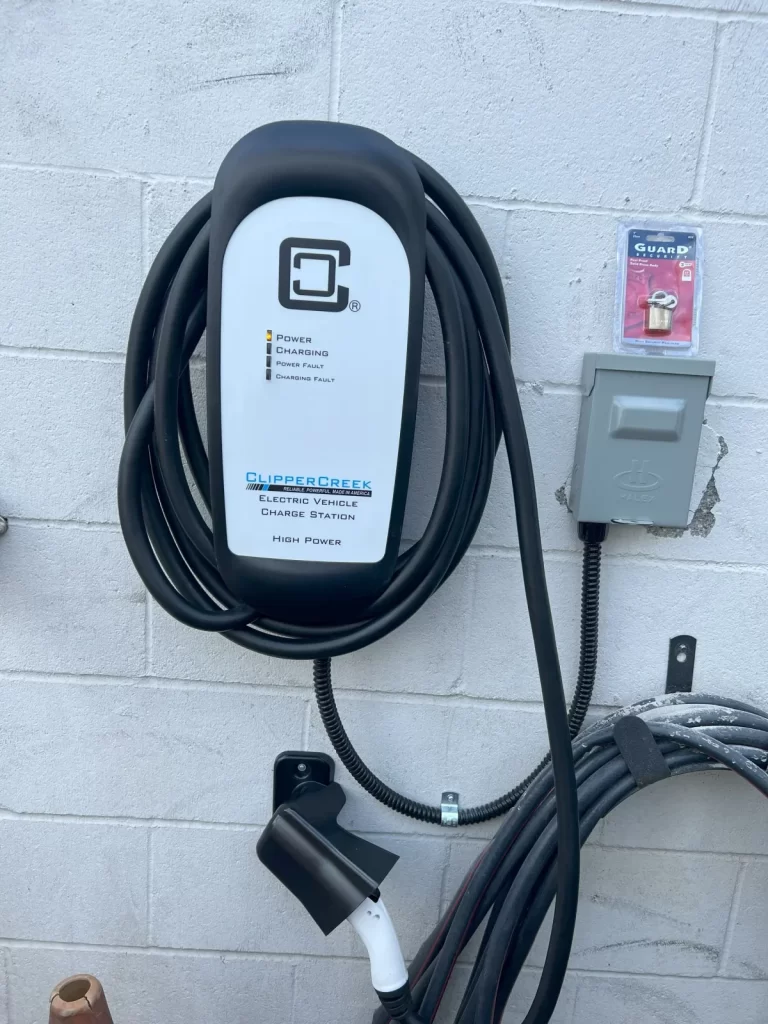 An electric car charger is attached to a brick wall